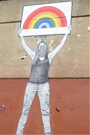Woman holding up a rainbow sign