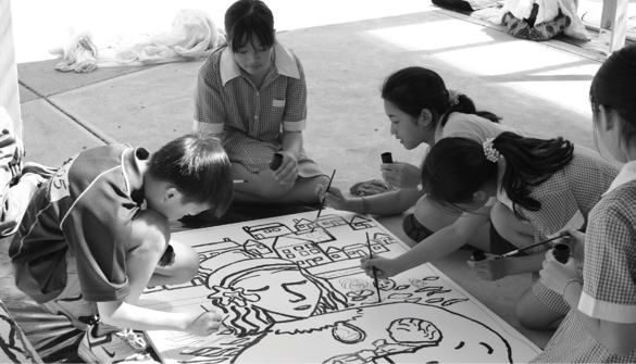 School students painting a large picture together.