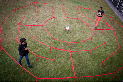 Two people inside maze made with red string