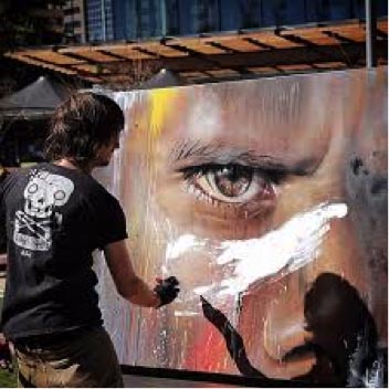 Adnate at work, painting a picture of a face.
