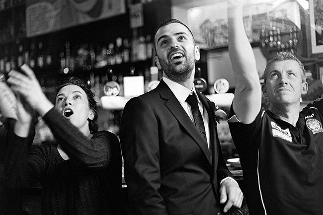 Three football supporters cheering at pub